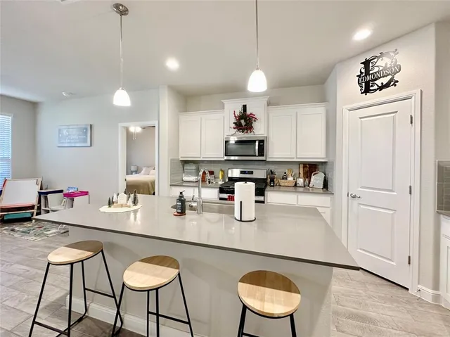 a kitchen with stainless steel appliances granite countertop a sink and a refrigerator