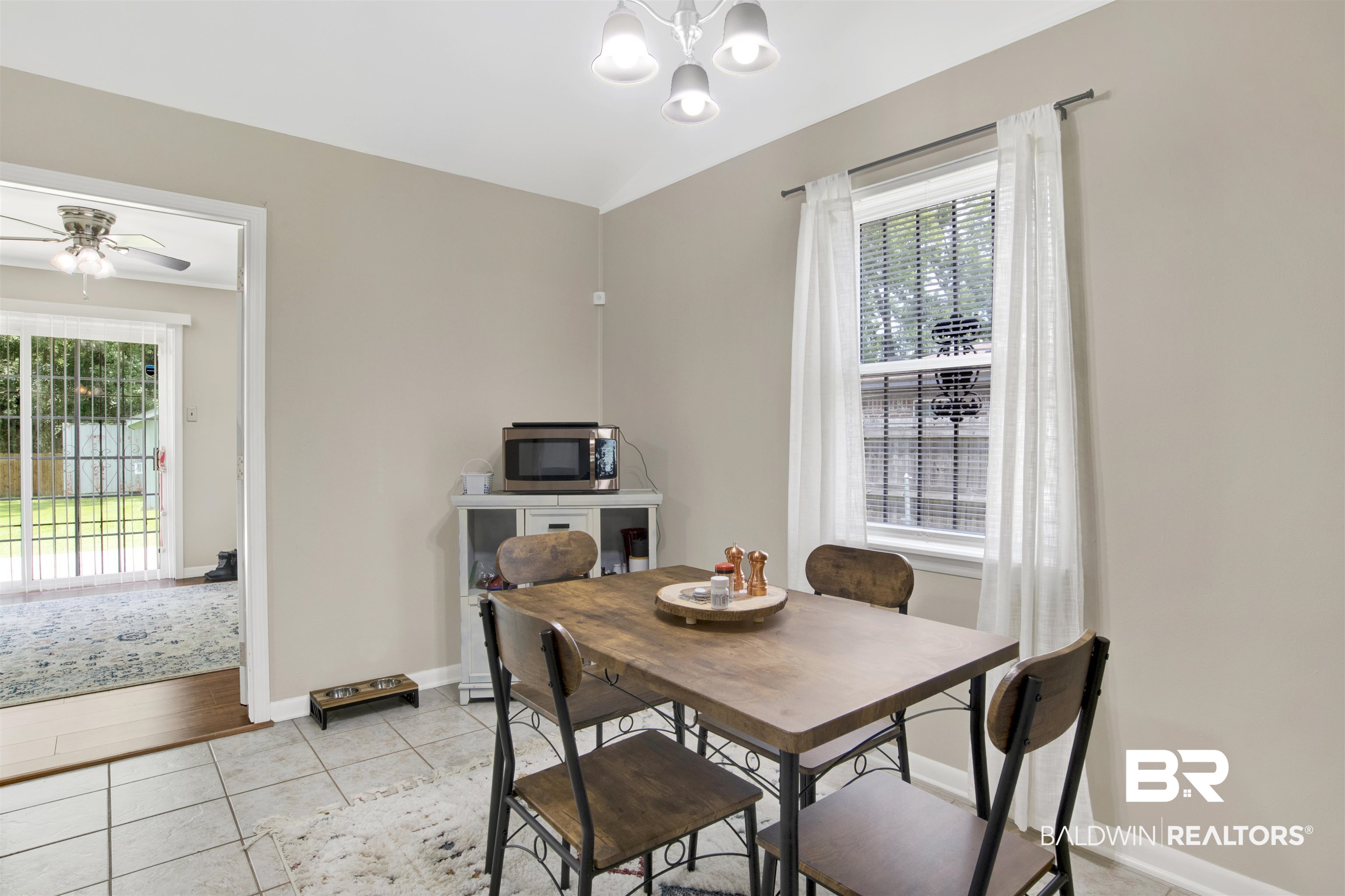 1476 Boudousquie Street Mobile, AL 36605 - Photo 15 of 34 Dining area with a chandelier, light tile patterned floors, ceiling fan, and vaulted ceiling