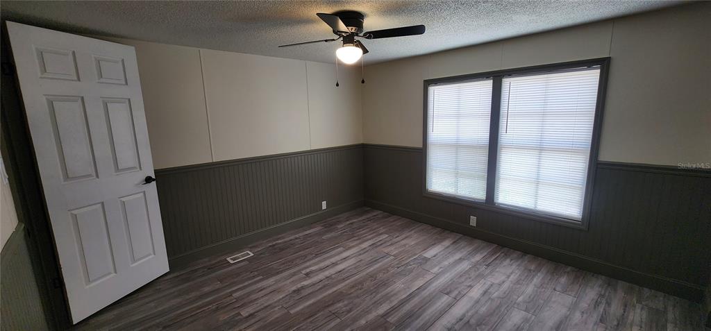 19865 Southwest 5th Place Dunnellon, FL 34431 - Photo 78 of 78 an empty room with wooden floor cabinet and windows