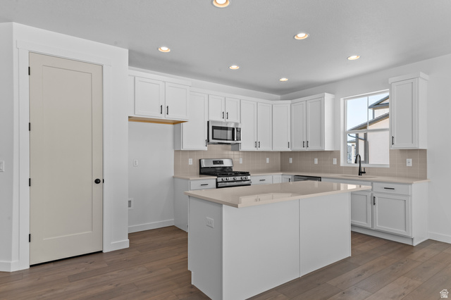 3016 West 2650 North Clinton, UT 84015 - Photo 15 of 20 Kitchen with stainless steel appliances, white cabinets, dark wood-style floors, backsplash, and recessed lighting