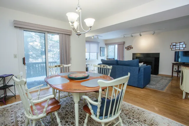 a view of a dining room with furniture a chandelier and wooden floor