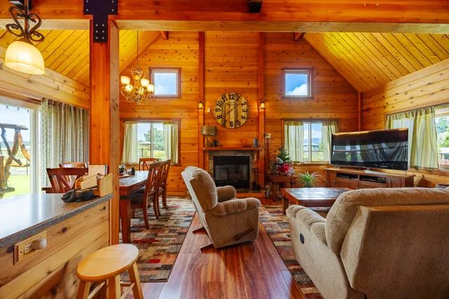 a living room with fireplace furniture and a large window