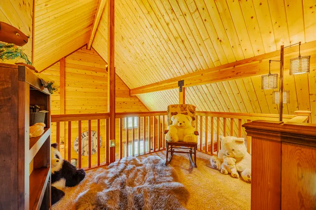 a living room with a balcony a fireplace and a flat screen tv