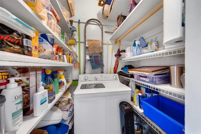 a utility room with dryer washer and a rug