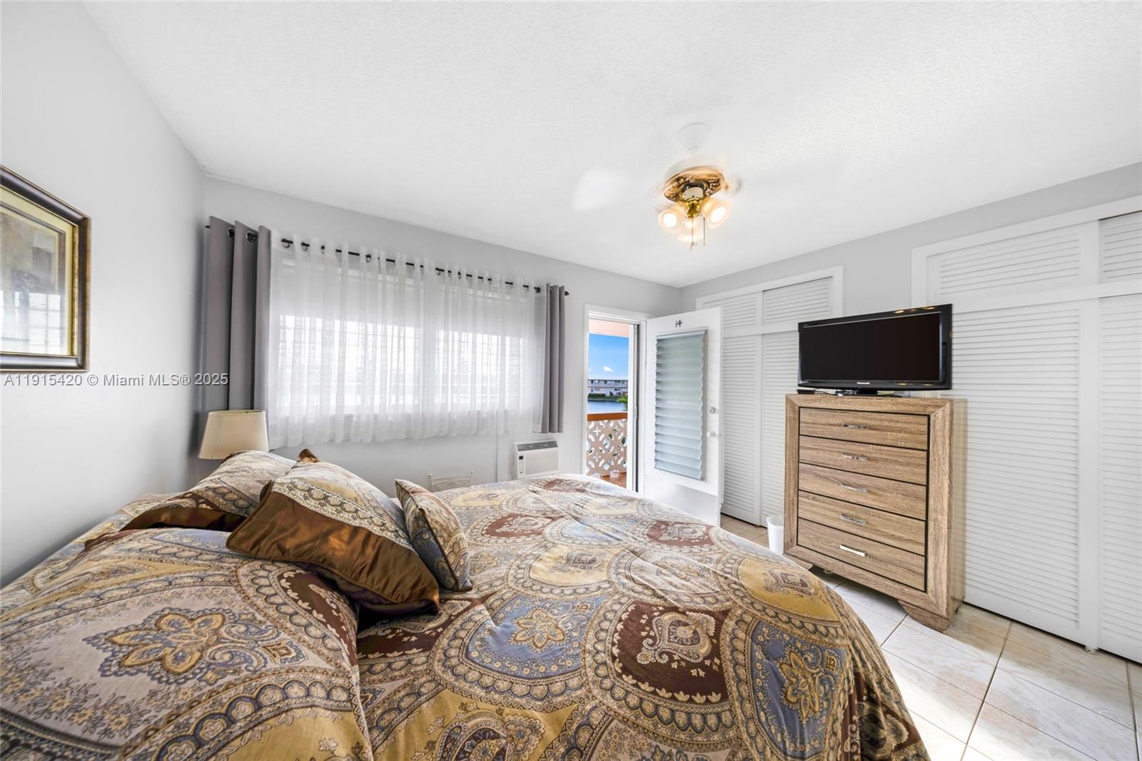 900 Southwest 10th Terrace, Unit 14S Hallandale Beach, FL 33009 - Photo 14 of 31 a bedroom with a bed and flat screen tv