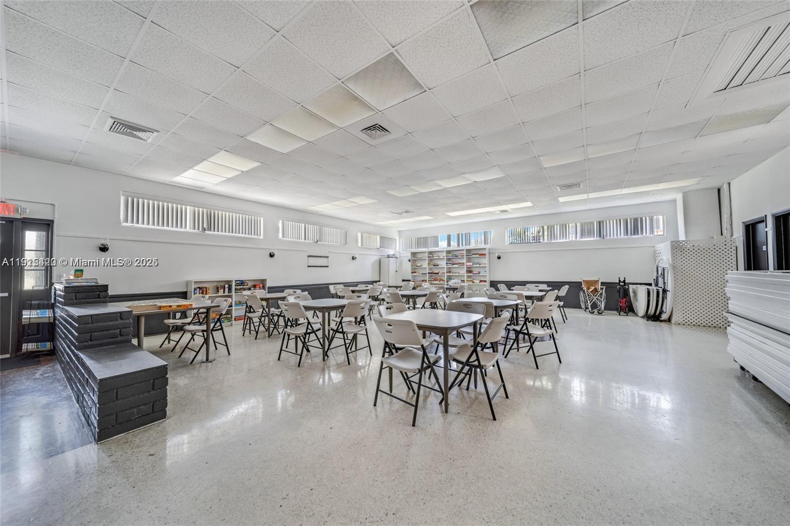 900 Southwest 10th Terrace, Unit 14S Hallandale Beach, FL 33009 - Photo 24 of 31 a dining hall with stainless steel appliances lots of white furniture a dining table and chairs