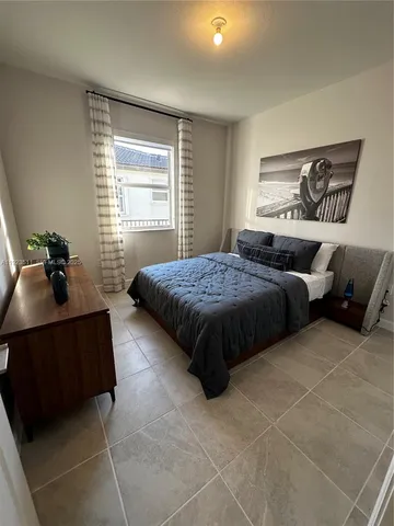 a bedroom with a bed a dresser and mirror