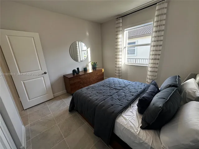 a bedroom with a bed a dresser and mirror