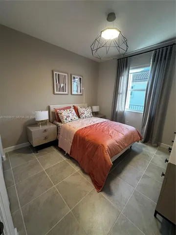 a bed sitting in a bedroom next to a window