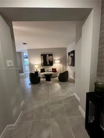 a living room with furniture a flat screen tv and a window