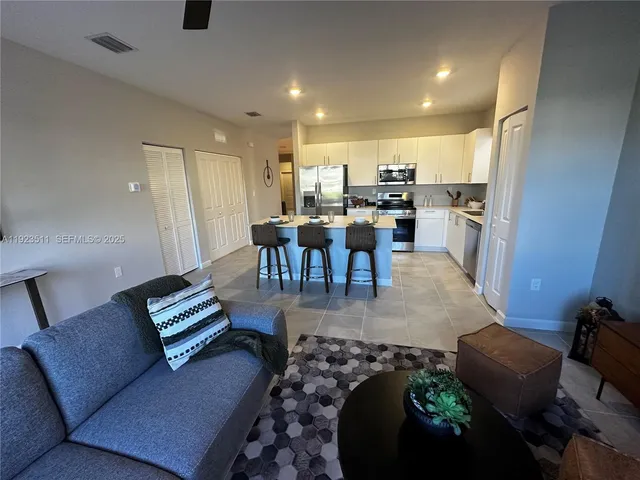 a living room with furniture and a dining table with rug