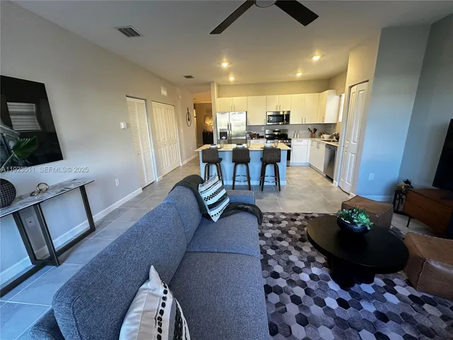 a living room with furniture a dining table and kitchen view