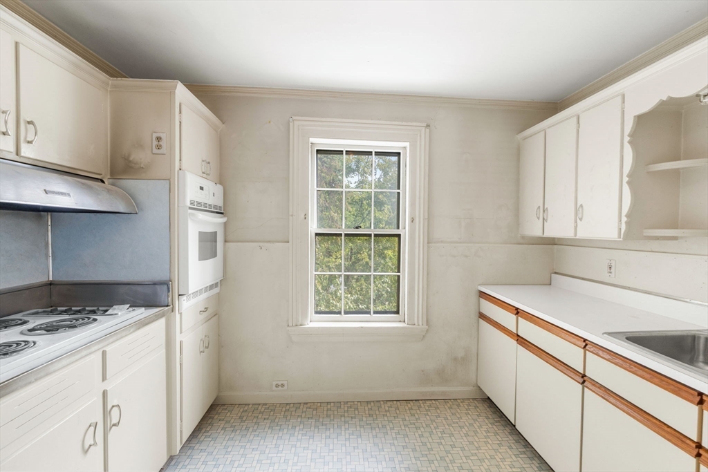 16 Ditson Place Methuen, MA 01844 - Photo 14 of 39 a kitchen with a white cabinets and a stove top oven
