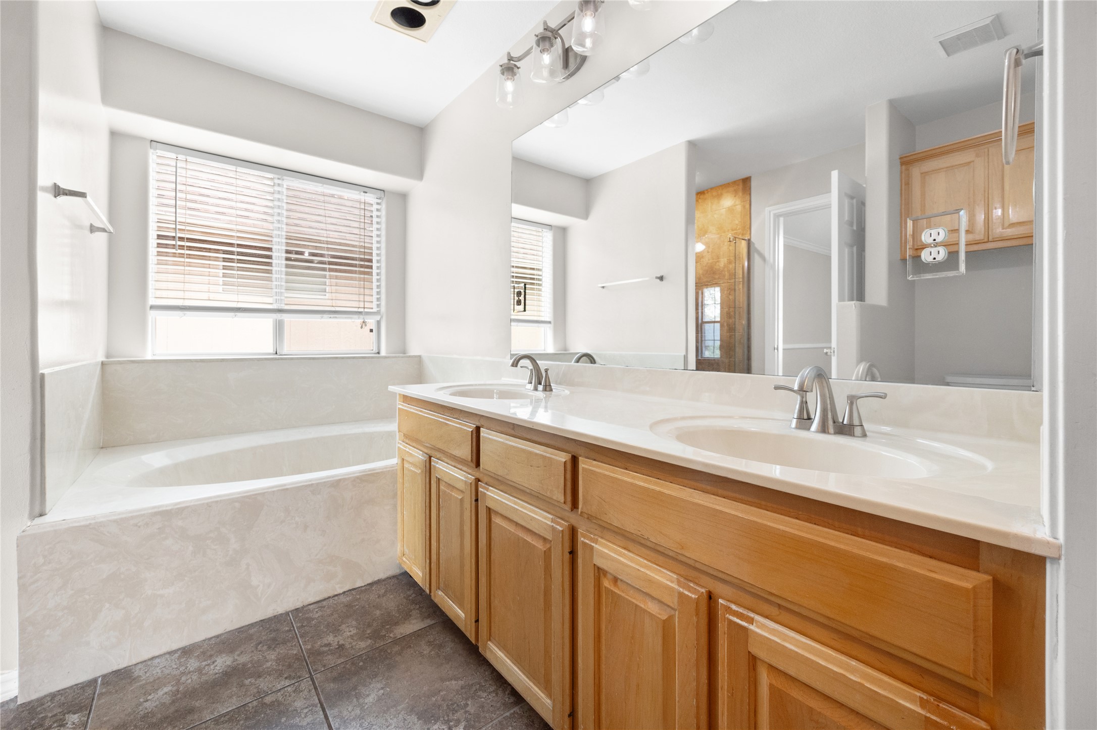 13217 Rochester Lane Austin, TX 78753 - Photo 19 of 30 A spacious vanity and deeply inset soaking tub define this functional, tile-floored bathroom.