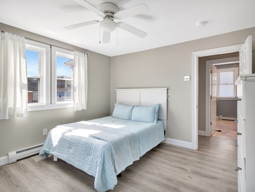 47 B Street, Unit BEACHSIDE Hull, MA 02045 - Photo 29 of 42 a bedroom with a large bed and a chandelier fan