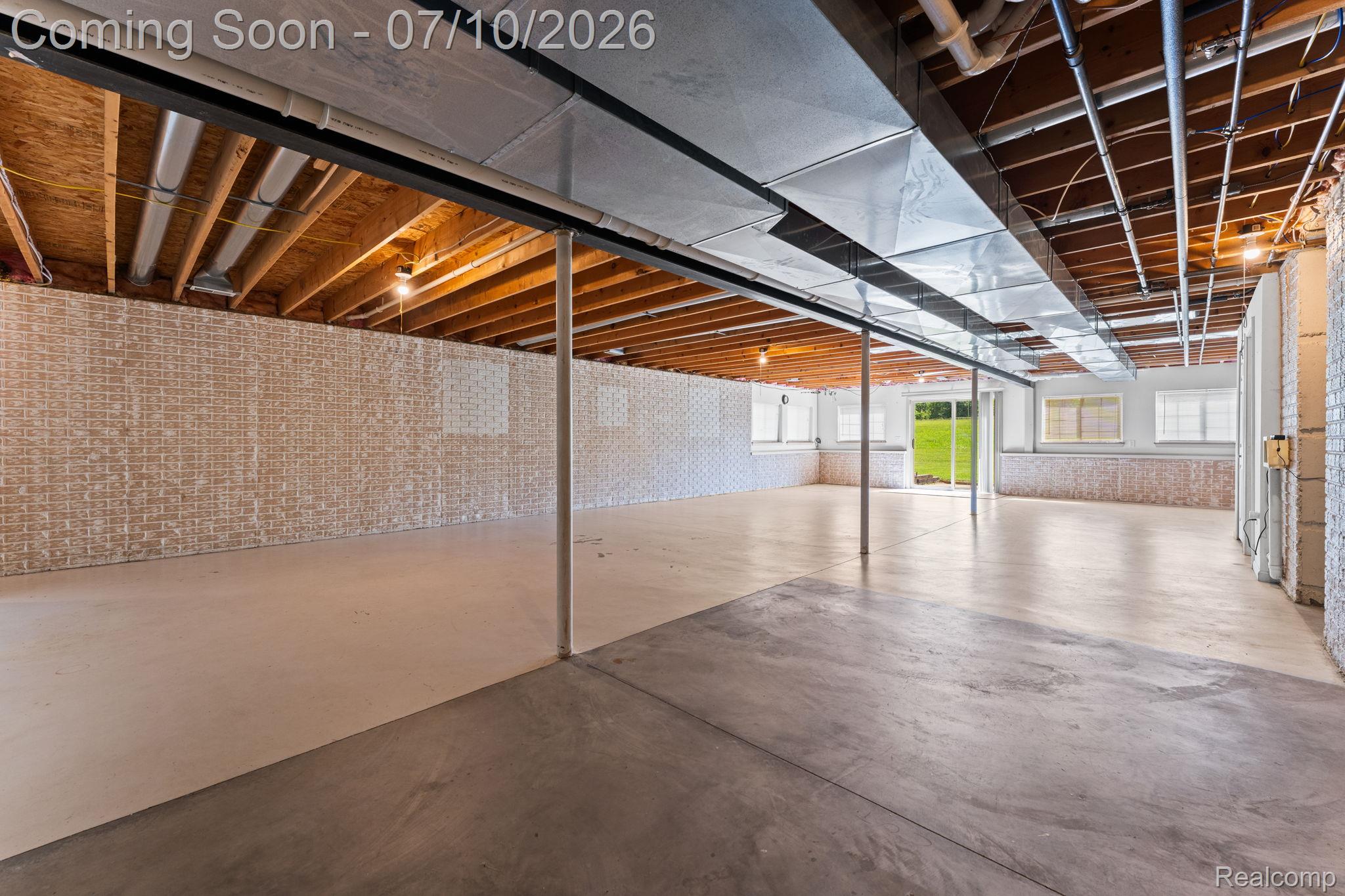 3144 North Nicholson Road Fowlerville, MI 48836 - Photo 61 of 70 Expansive unfinished basement featuring concrete flooring, exposed wooden ceiling joists, and multiple windows providing natural light