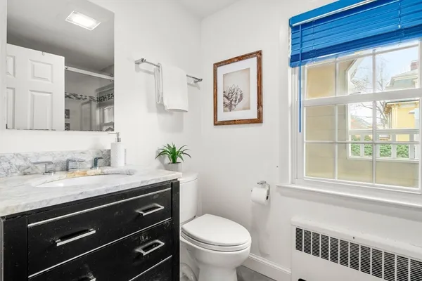a bathroom with a granite countertop sink toilet and a mirror