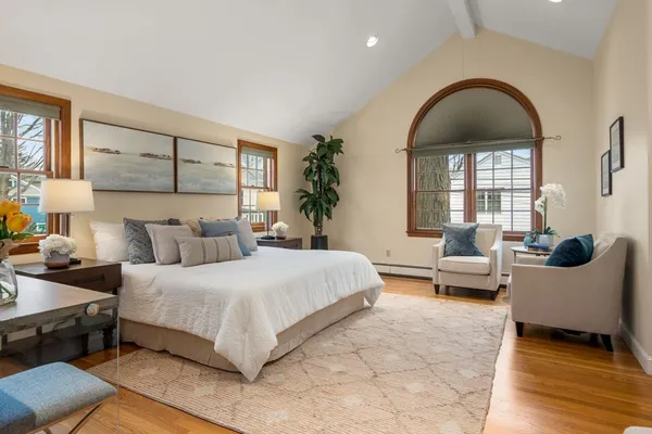 a spacious bedroom with a bed and wooden floor