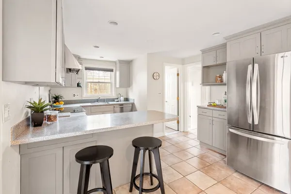 a kitchen with granite countertop a refrigerator a stove a sink and dishwasher with wooden floor