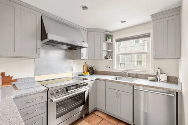 a kitchen with cabinets appliances a sink and a window