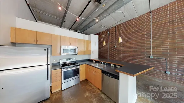 a kitchen with stainless steel appliances granite countertop a stove a sink and a refrigerator