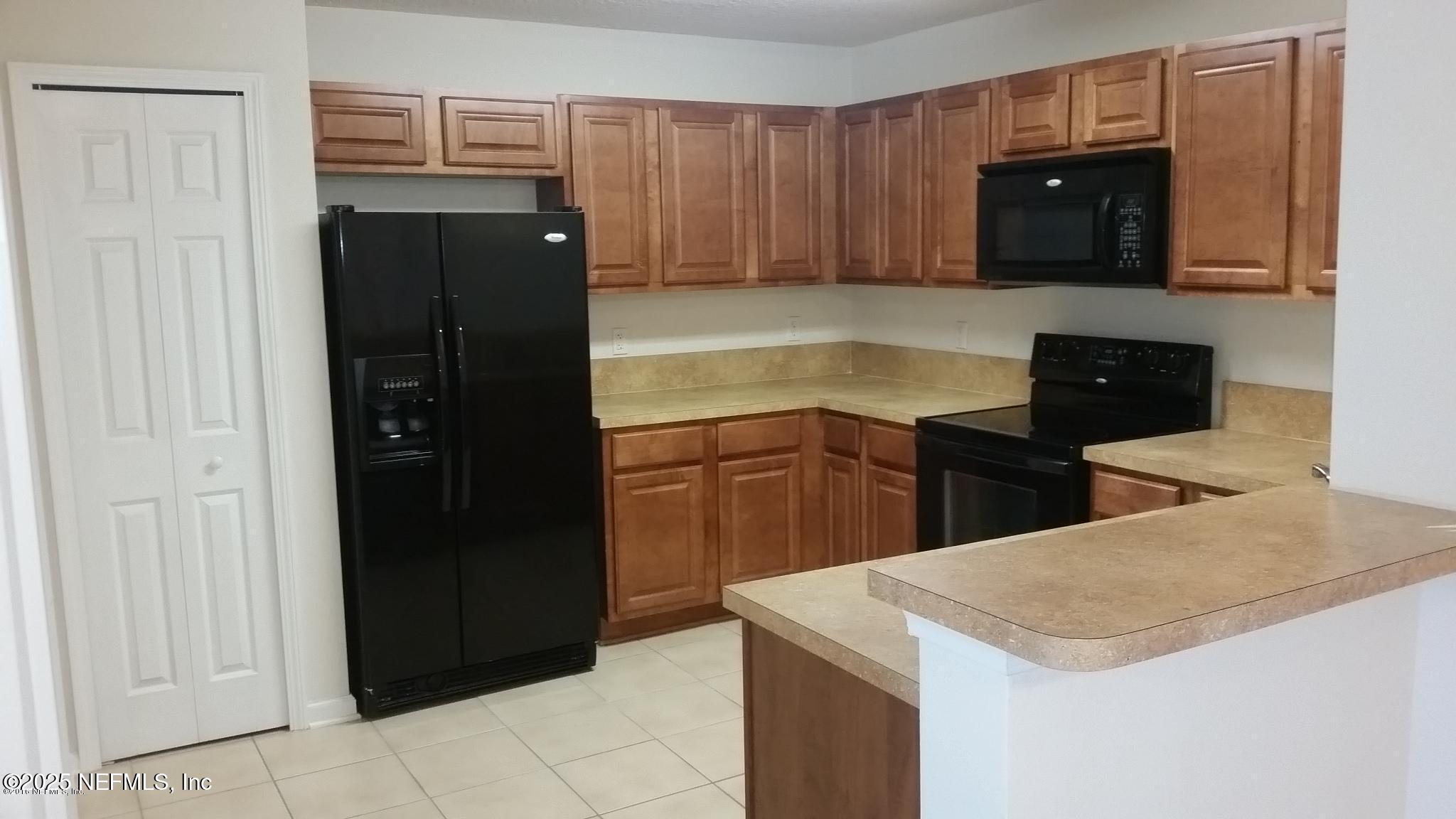 3620 Kirkpatrick Circle, Unit 16 Jacksonville, FL 32210 - Photo 5 of 17 a kitchen with a refrigerator and cabinets