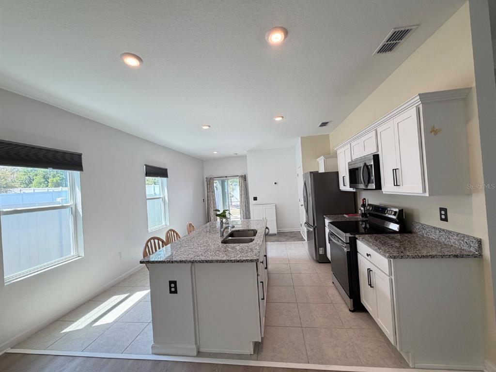 2021 Hemingway Circle Groveland, FL 34736 - Photo 13 of 18 a kitchen with granite countertop a sink stove and cabinets