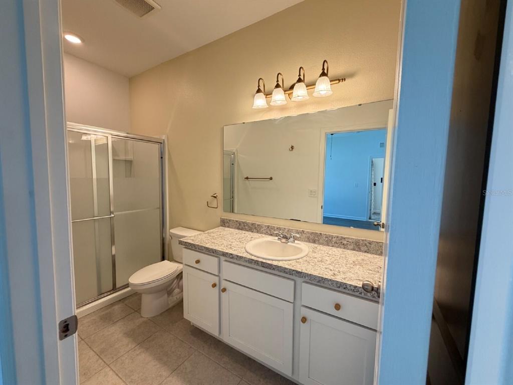 2021 Hemingway Circle Groveland, FL 34736 - Photo 7 of 18 a bathroom with a granite countertop sink toilet and shower