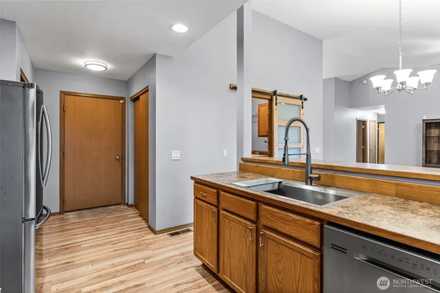 a kitchen with stainless steel appliances granite countertop a sink and dishwasher with wooden floor