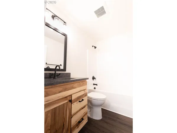 a bathroom with a sink a toilet and a mirror