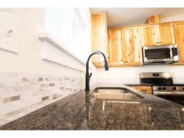 a kitchen with a sink a stove and a microwave
