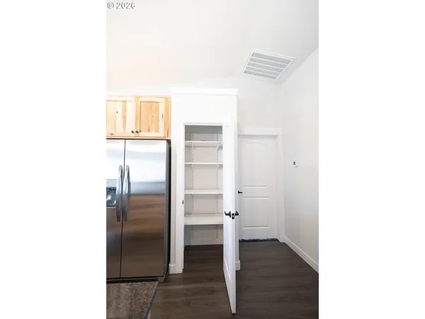 a view of a kitchen from the hallway with a bathroom