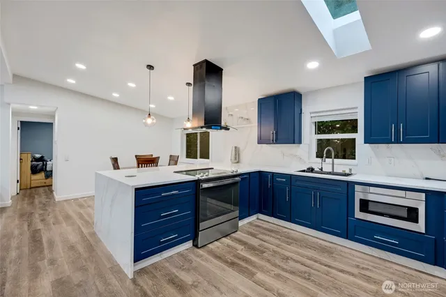 a kitchen with stainless steel appliances granite countertop wooden cabinets a stove top oven a sink and dishwasher