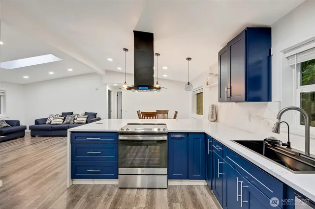 a kitchen with stainless steel appliances kitchen island granite countertop a sink stove and cabinets