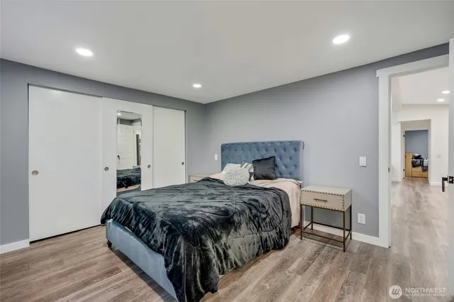 a bedroom with a bed and wooden floor