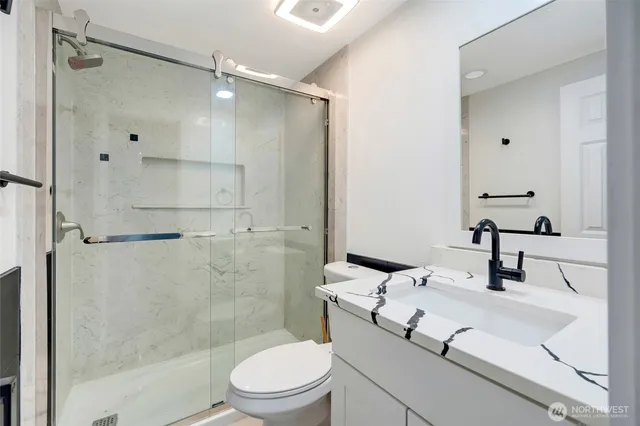 a bathroom with a sink a toilet and shower