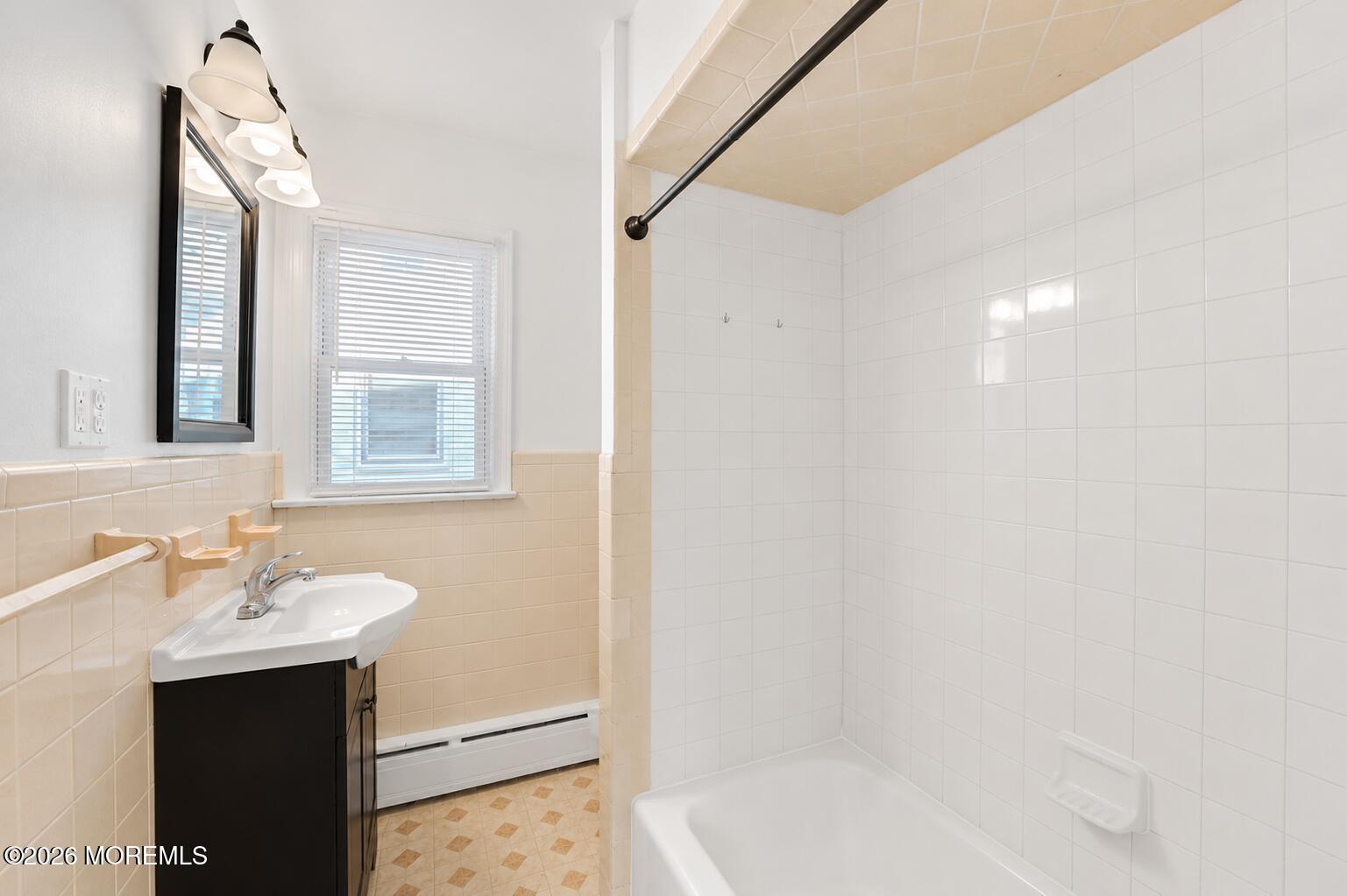 1 Gaston Avenue, Unit UPSTAIRS Raritan, NJ 08869 - Photo 6 of 11 a bathroom with a sink mirror and a bathtub