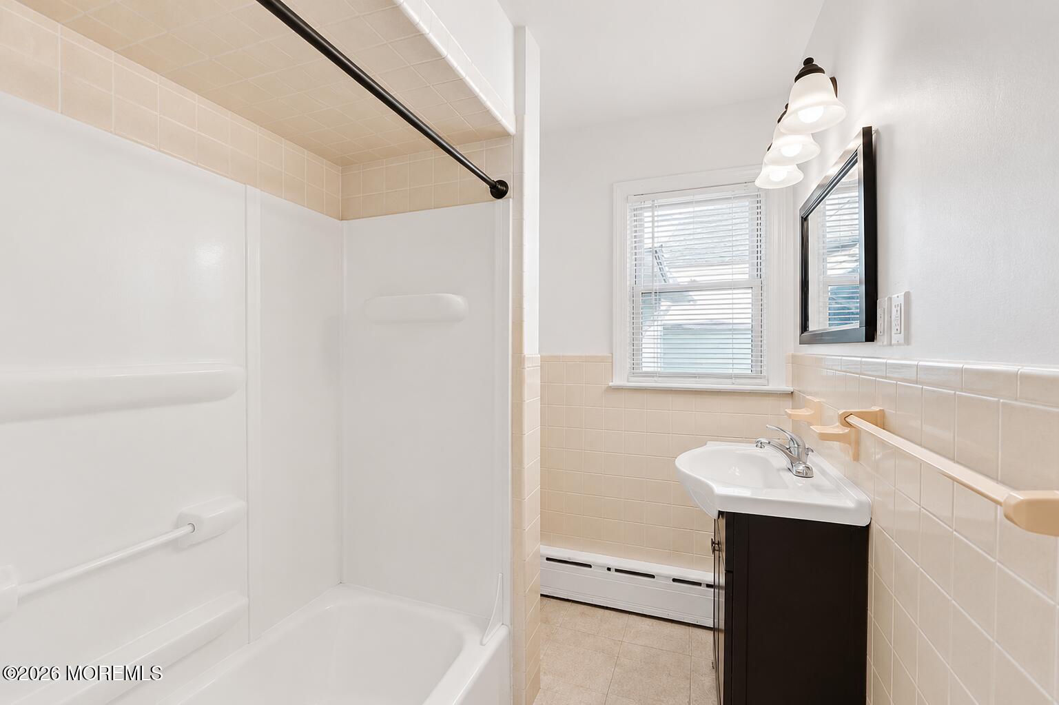 1 Gaston Avenue, Unit UPSTAIRS Raritan, NJ 08869 - Photo 9 of 11 a bathroom with a sink a mirror and a bathtub