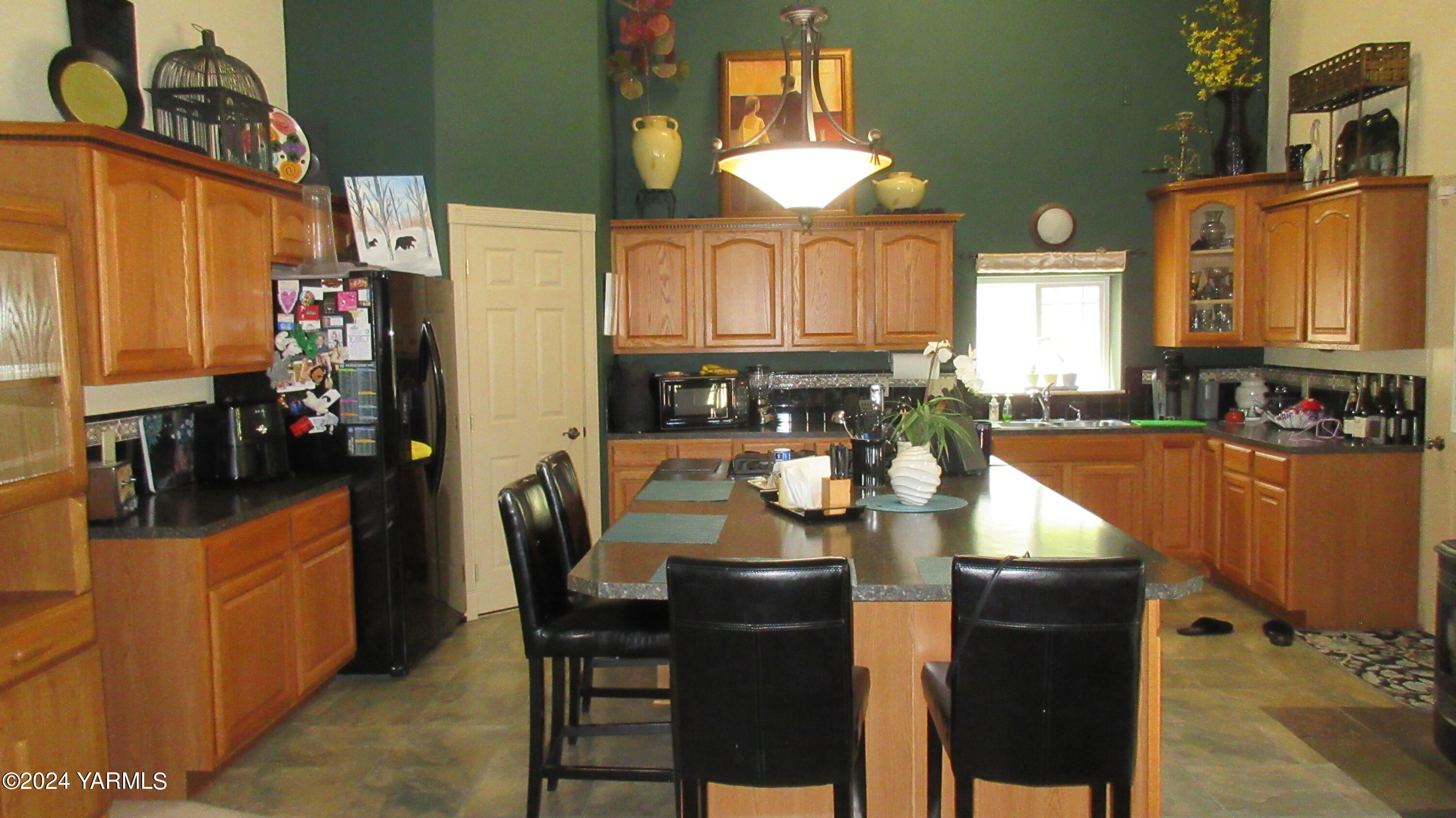 455 Rosenkranz Road Tieton, WA 98947 - Photo 6 of 14 a kitchen with stainless steel appliances granite countertop a stove top oven a sink a dining table and chairs with wooden floor