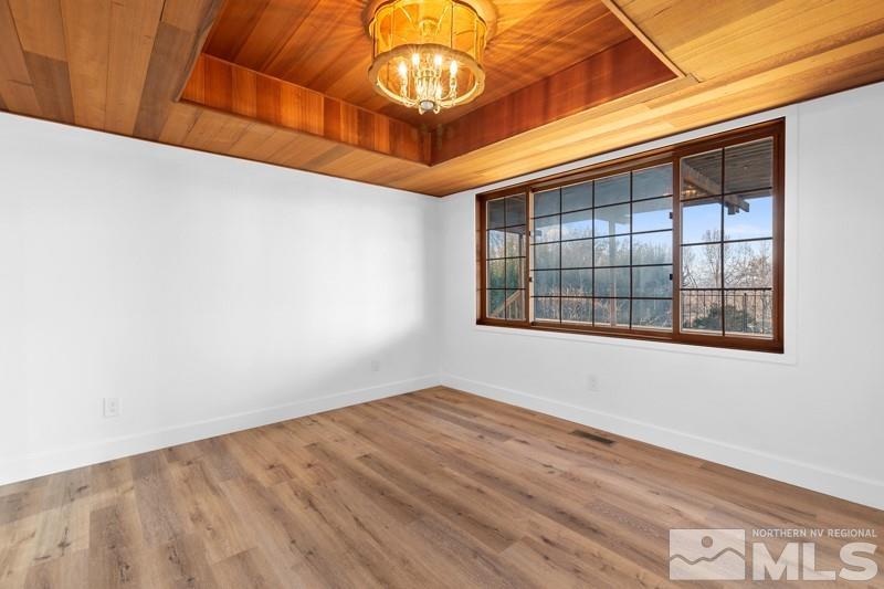 7270 Pembroke Drive Reno, NV 89502 - Photo 11 of 38 an empty room with wooden floor and windows