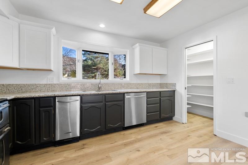 7270 Pembroke Drive Reno, NV 89502 - Photo 14 of 38 a kitchen with stainless steel appliances granite countertop a stove a sink and a granite counter tops with white cabinets