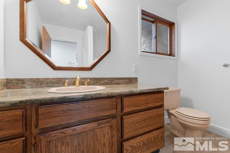 7270 Pembroke Drive Reno, NV 89502 - Photo 18 of 38 a bathroom with a granite countertop toilet sink and mirror