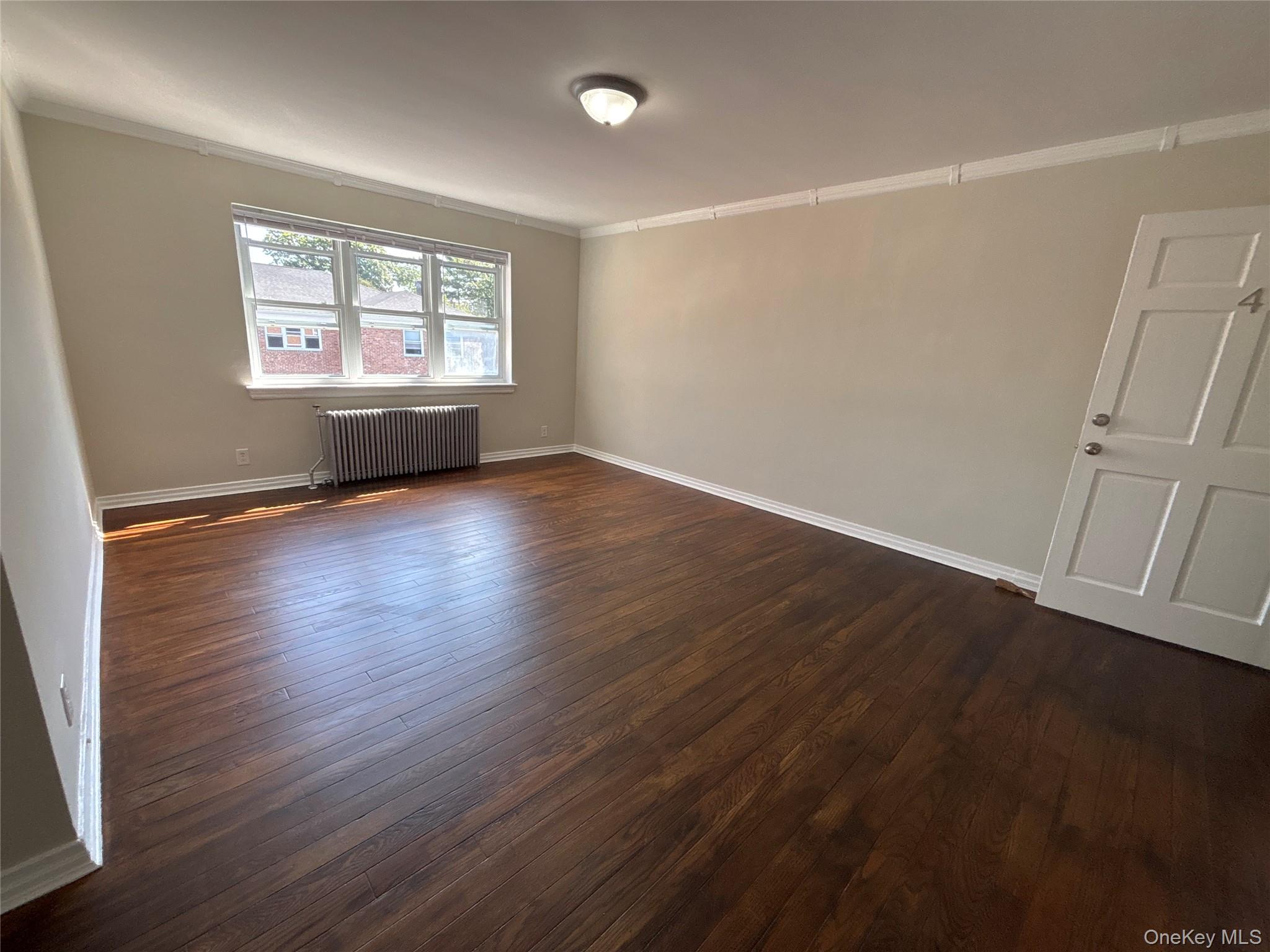 37 Spruce Street, Unit 2 Great Neck, NY 11021 - Photo 3 of 18 an empty room with wooden floor and windows