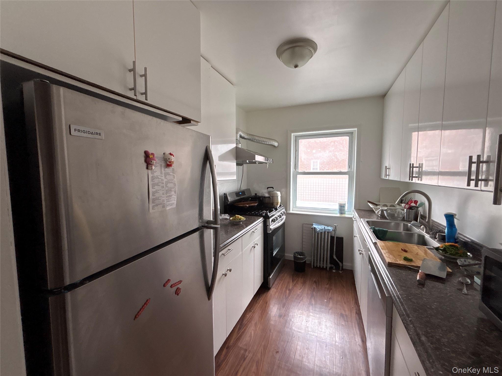 37 Spruce Street, Unit 2 Great Neck, NY 11021 - Photo 4 of 18 a kitchen with a refrigerator a sink and wooden floor