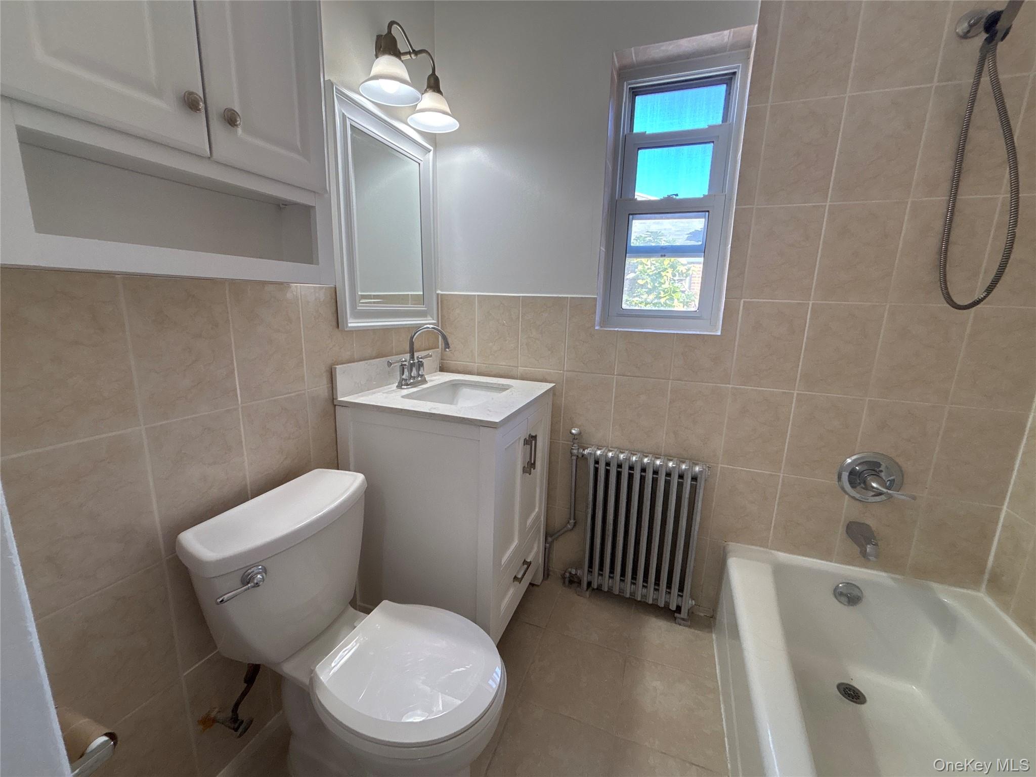 37 Spruce Street, Unit 2 Great Neck, NY 11021 - Photo 9 of 18 a bathroom with a toilet a sink and bathtub