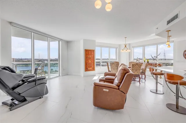 a kitchen with kitchen island granite countertop a refrigerator a stove a sink dishwasher and white cabinets with wooden floor