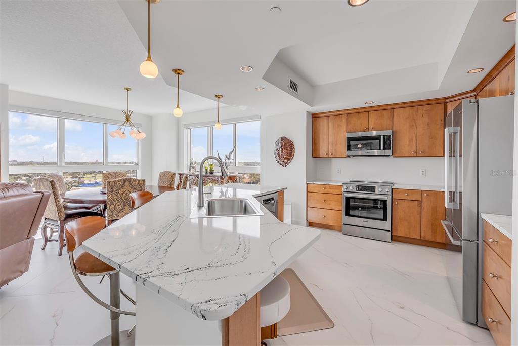 231 Riverside Drive, Unit 7091 Daytona Beach, FL 32117 - Photo 15 of 90 a kitchen with stainless steel appliances a stove a sink a microwave a center island and chairs