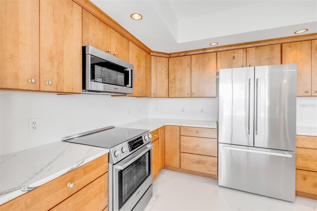 231 Riverside Drive, Unit 7091 Daytona Beach, FL 32117 - Photo 17 of 90 a kitchen with stainless steel appliances white cabinets and a microwave oven