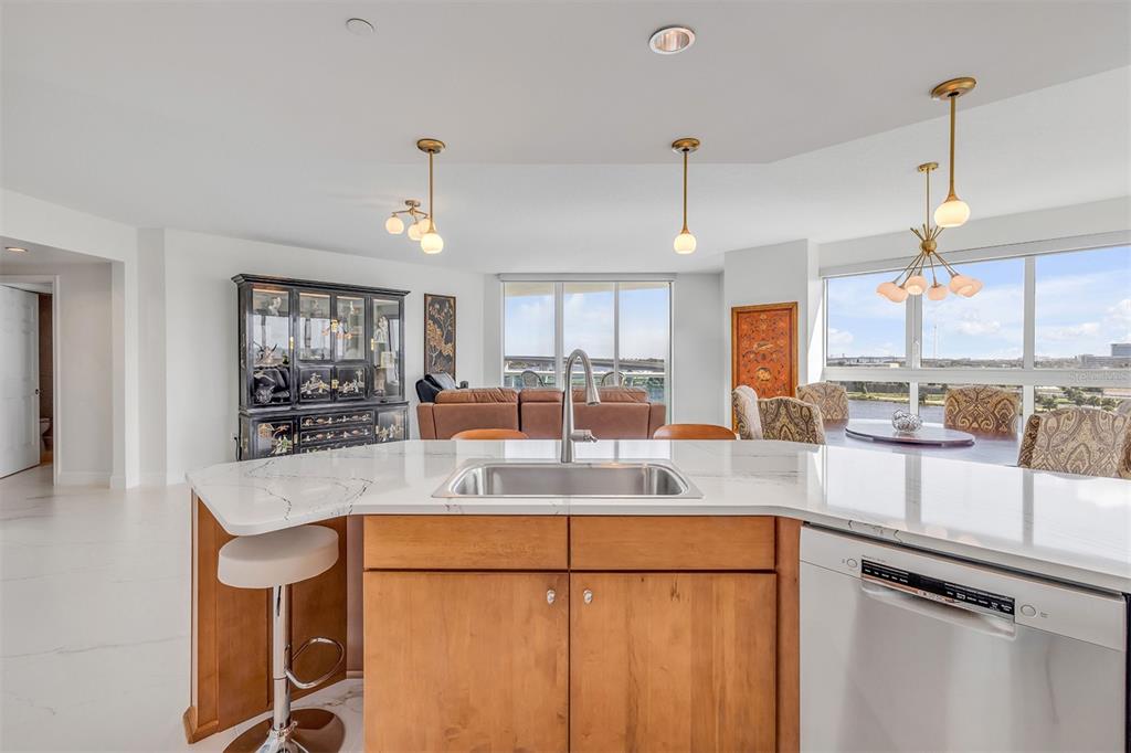 231 Riverside Drive, Unit 7091 Daytona Beach, FL 32117 - Photo 19 of 90 a kitchen with kitchen island granite countertop a refrigerator a stove a sink dishwasher and white cabinets with wooden floor