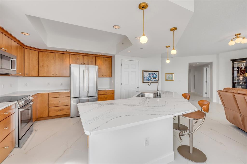 231 Riverside Drive, Unit 7091 Daytona Beach, FL 32117 - Photo 21 of 90 a view of kitchen with granite countertop a sink a stove and a wooden floors